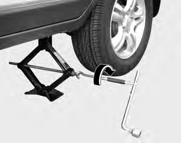 8. Insert the jack handle into the jack and turn it clockwise, raising the vehicle